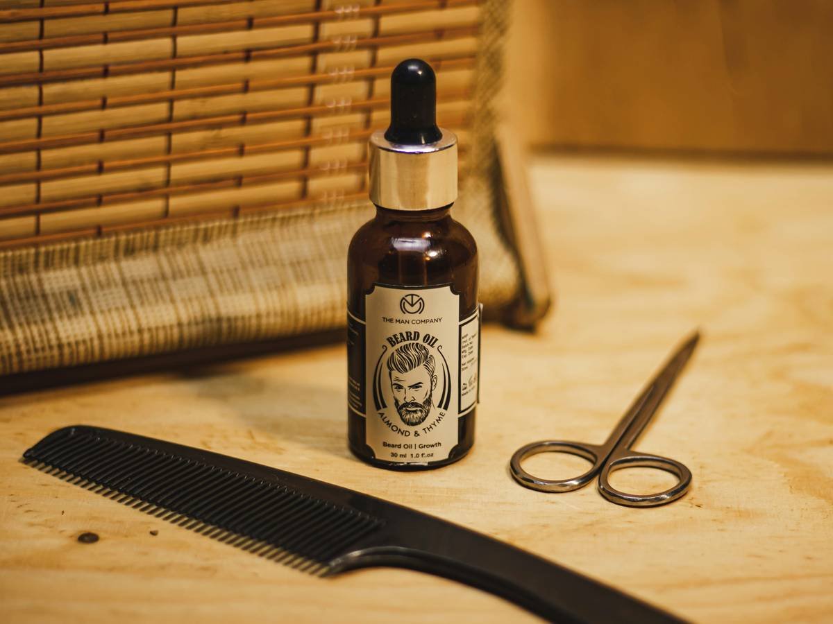 close-up of grooming kit gift pack for men showing beard oil dropper and textured handle scissors