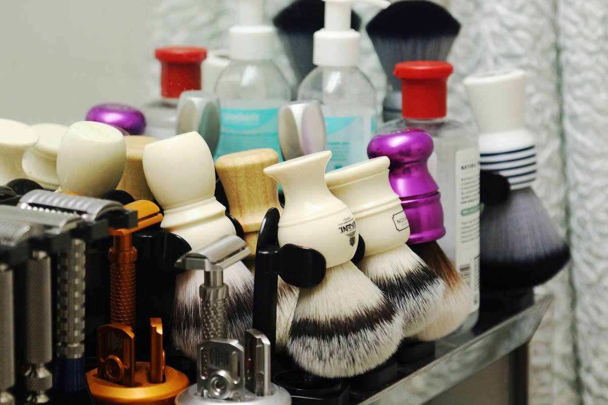 beard grooming kit best sellers laid out on wooden surface with oil, brush, comb and scissors