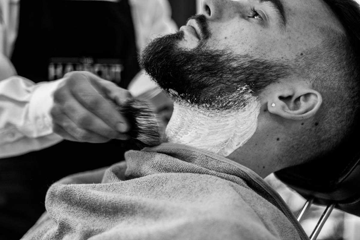 close-up of hand applying beard oil from beard grooming starter pack for beginners